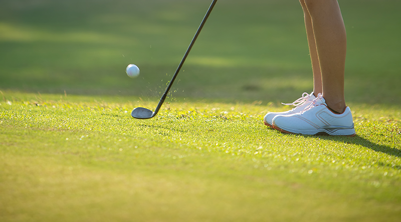 Mastering the Short Game [Blog Post] Image shows a golfer using an iron to hit a ball on the golf course.
