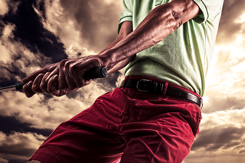 Golfer grip and hands on club showing pressure control from ground-up swing perspective