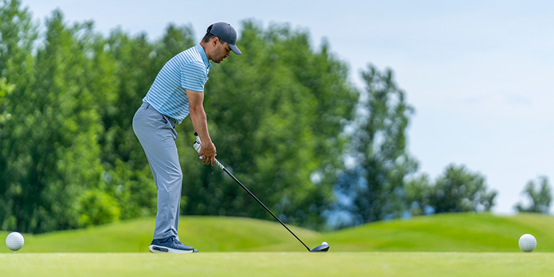 Golfer stance at address viewed from down the line showing balance and posture