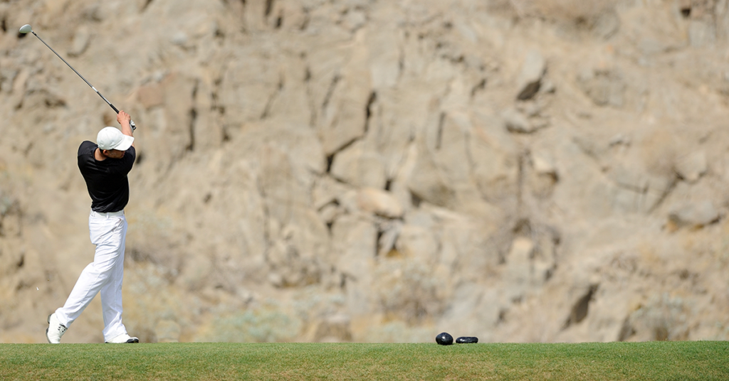 Golfer holding a balanced finish position after a tee shot