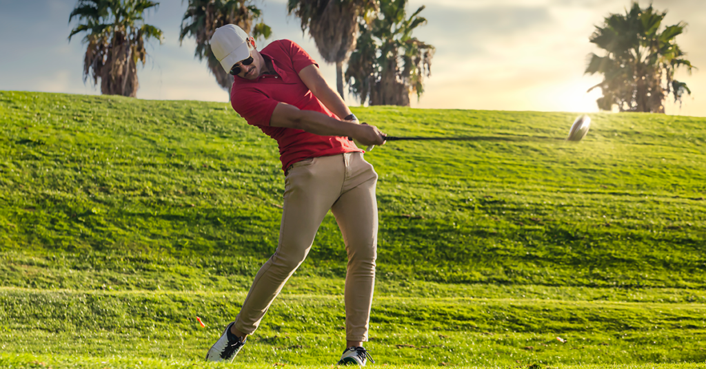 Golfer rotating through impact with open hips during a powerful driver swing